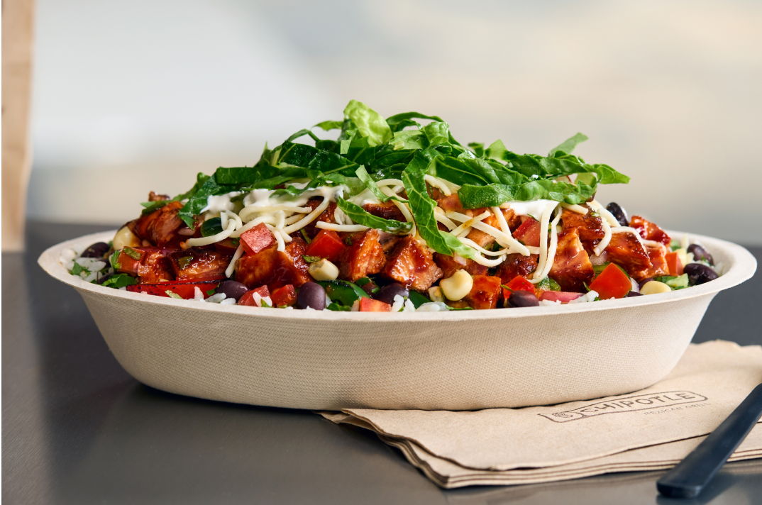 A Chipotle Honey Chicken Burrito Bowl with White Rice, Black Beans, Fajita Veggies, freshly grilled chicken, Fresh Tomato Salsa, hand-mashed Guac, and Monterey Jack shredded cheese.